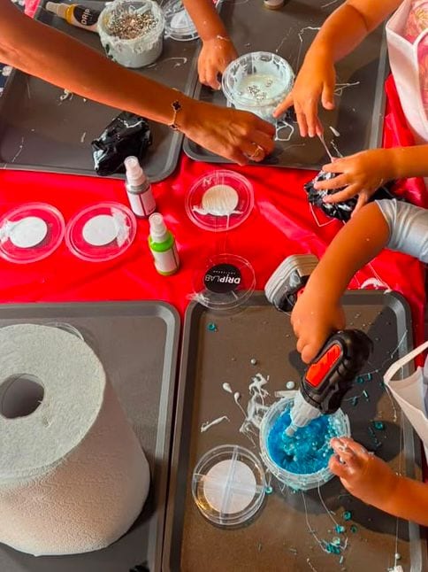 Handen mengen materialen tijdens een begeleide workshop
