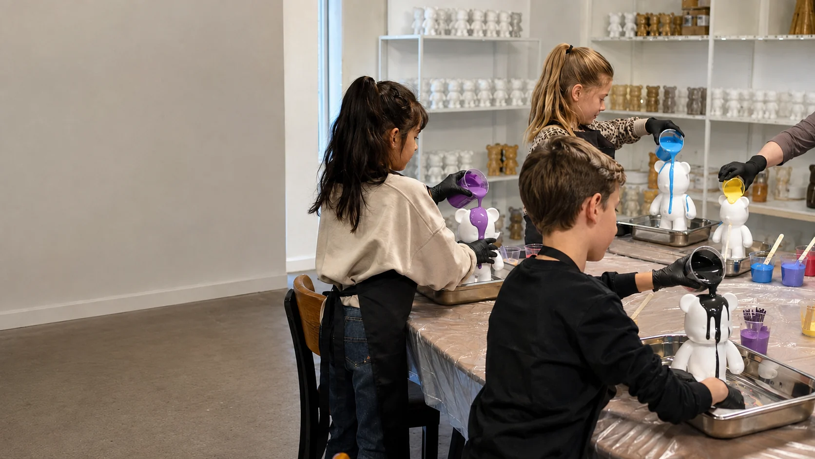 Kinderen gieten gekleurde verf over witte art bears