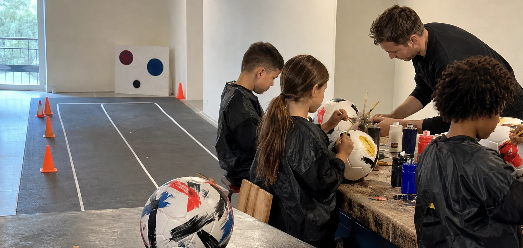 Kinderen beschilderen voetballen tijdens Football Lab